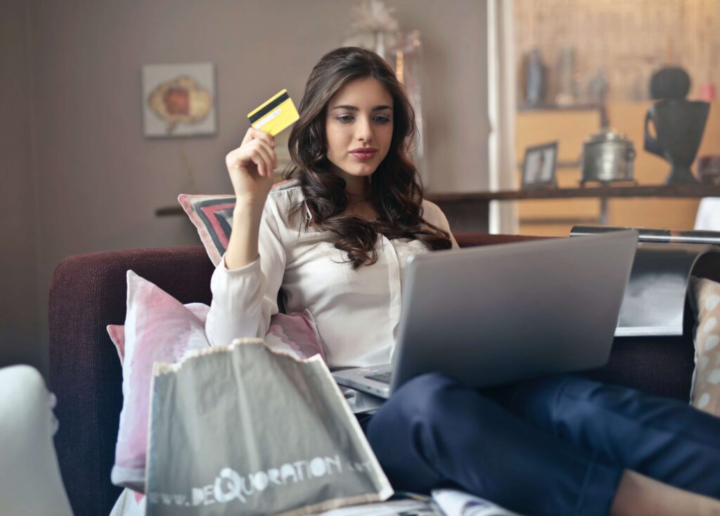 Noia comprant per internet a un ecommerce amb la targeta de crèdit a la mà